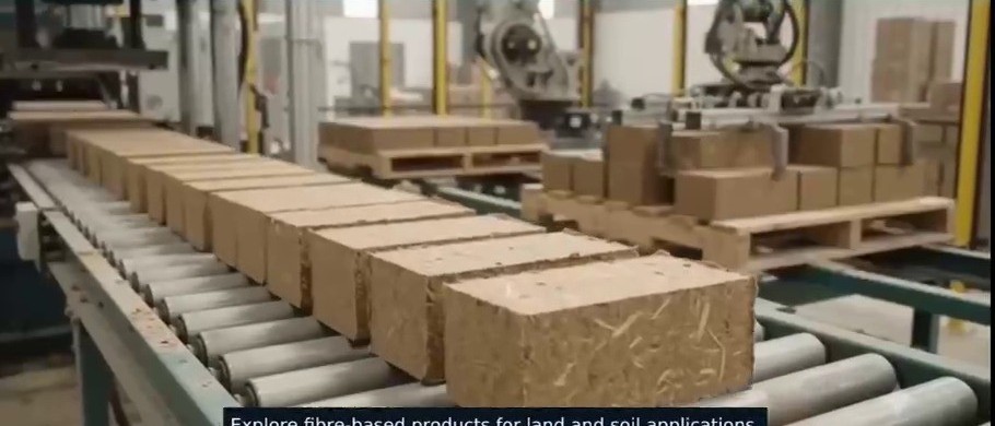Pressed fibre bio-bricks moving along the production conveyor — concept visualisation